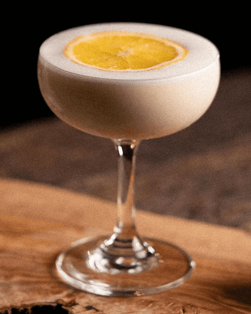 Close detail of the Gift of Gold's orange wheel garnish floating on the cream surface.