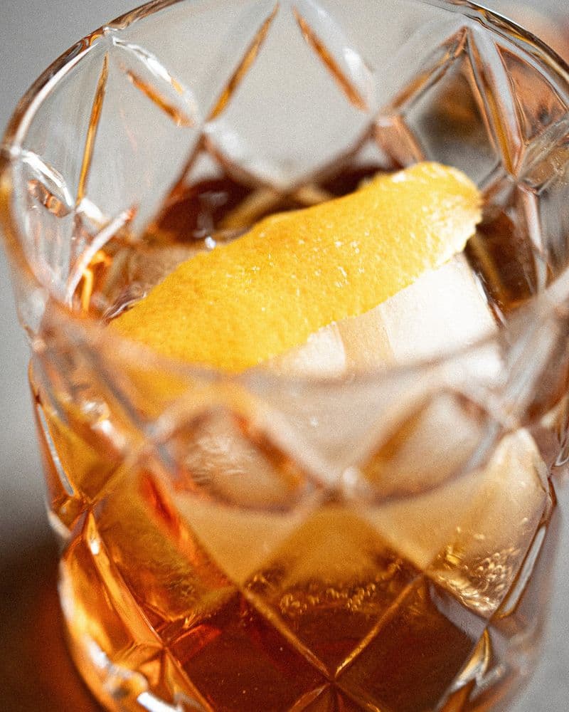 Demerara rum, pecan liqueur, and hazelnut being stirred smoothly over ice in a mixing glass.